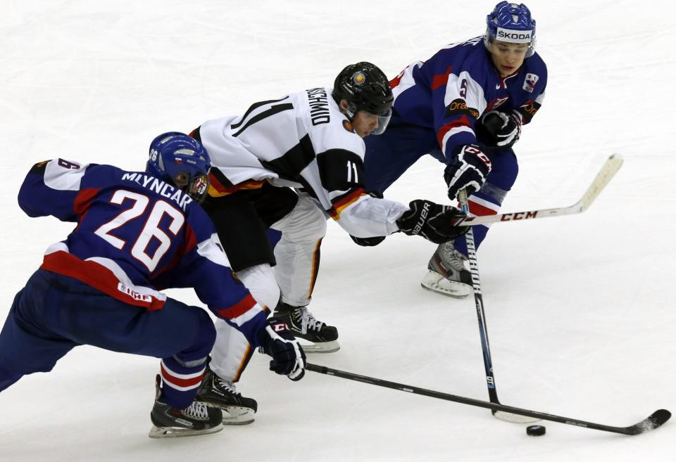 Germany's Eisenschmid fights for the puck with Slovakia's Mlyncar and Valjent during the second period of their IIHF World Junior Championship ice hockey game in Malmo