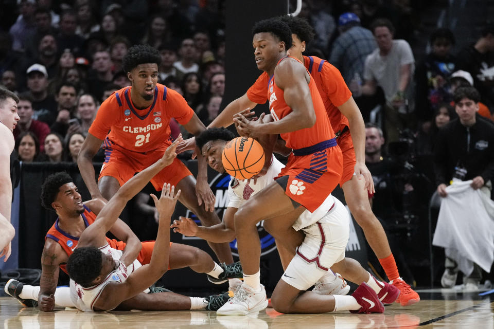 Alabama and Clemson players scramble for a loose ball during the first half of an Elite 8 college basketball game in the NCAA tournament Saturday, March 30, 2024, in Los Angeles. (AP Photo/Ashley Landis)