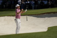 Cameron Smith, of Australia, jumps up to see the pin from a bunker on the fourth hole during the final round at the Masters golf tournament on Sunday, April 10, 2022, in Augusta, Ga. (AP Photo/Matt Slocum)