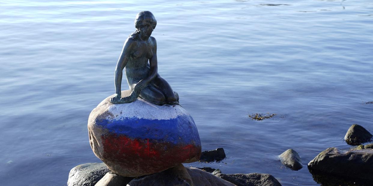 A view of the Little Mermaid statue in Copenhagen on March 2, 2023. The rock base on which it sits has been crudely daubed with the colors of the Russian flag.