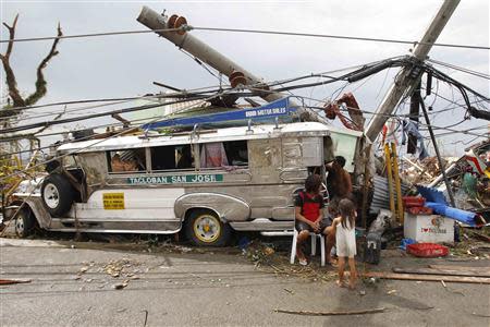 Survivors who lost their homes use a Jeepney public bus as shelter after a super Typhoon Haiyan battered Tacloban city, central Philippines November 9, 2013. REUTERS/Romeo Ranoco