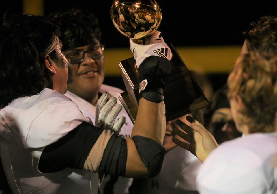 The Brady High School Bulldogs hold up the trophy after beating Stanton in a Class 3A Division II area playoff at Hawks Stadium in Wall on Friday, Nov. 19, 2021.