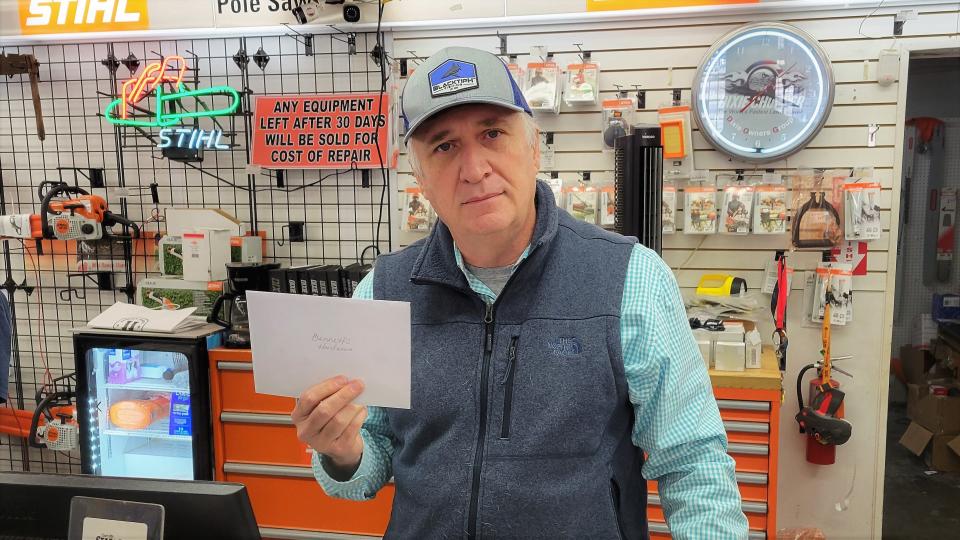 Glen Bennett holds one of the many get-well cards and notes he has received as his brothers recover from injuries suffered Friday when a truck crashed into their Bennett Ace Hardware store next door.