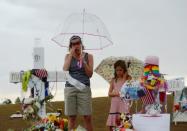 Traci Gillespie y su hija Avery, de siete años, delante de un altar instalado en la calle del cine de Aurora, en Colorado, donde se registró el tiroteo en el que murieron doce personas, el viernes 27 de julio. (AFP/GettyImages | Kevork Djansezian)