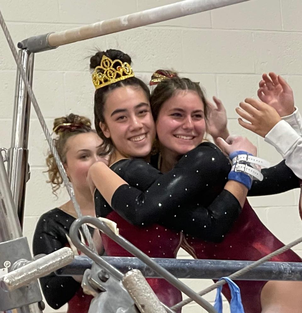 Algonquin's Maya Regan, left, wears the crown after competing on the bars and is greeted with a hug by Lily Maletta on Jan. 25, 2024 at a gymnastics meet in Northborough.