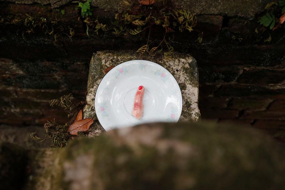 A finger made from a cast on a plate is left in it's hiding spot at Colonial Park Cemetery on December 14, 2022.