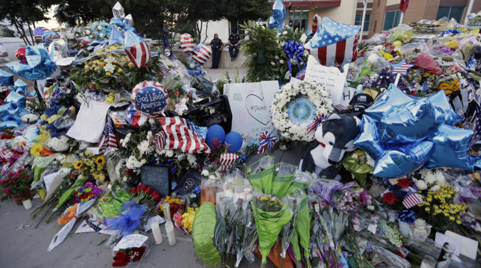 Dallas police officers keep watch over a makeshift memorial at the police headquarters