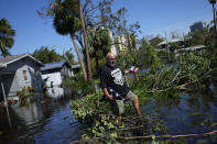 Retired marine Efrain Burgos Jr. recovers a lone personal item from a first visit to his flooded home, the American flag presented at the burial of his army veteran father, in Fort Myers, Fla. Thursday, Sept. 29, 2022. His daughter-in-law found the flag resting atop its cracked case in the receding floodwaters, not having touched the ground. Said Burgos of his flooded home, where water levels reached at least chest high, "It's done in there. I'm going to have to start all over." (AP Photo/Rebecca Blackwell)