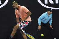 Australia's Nick Kyrgios plays the ball back between his legs to Russia's Karen Khachanov during their third round singles match at the Australian Open tennis championship in Melbourne, Australia, Saturday, Jan. 25, 2020. (AP Photo/Lee Jin-man)