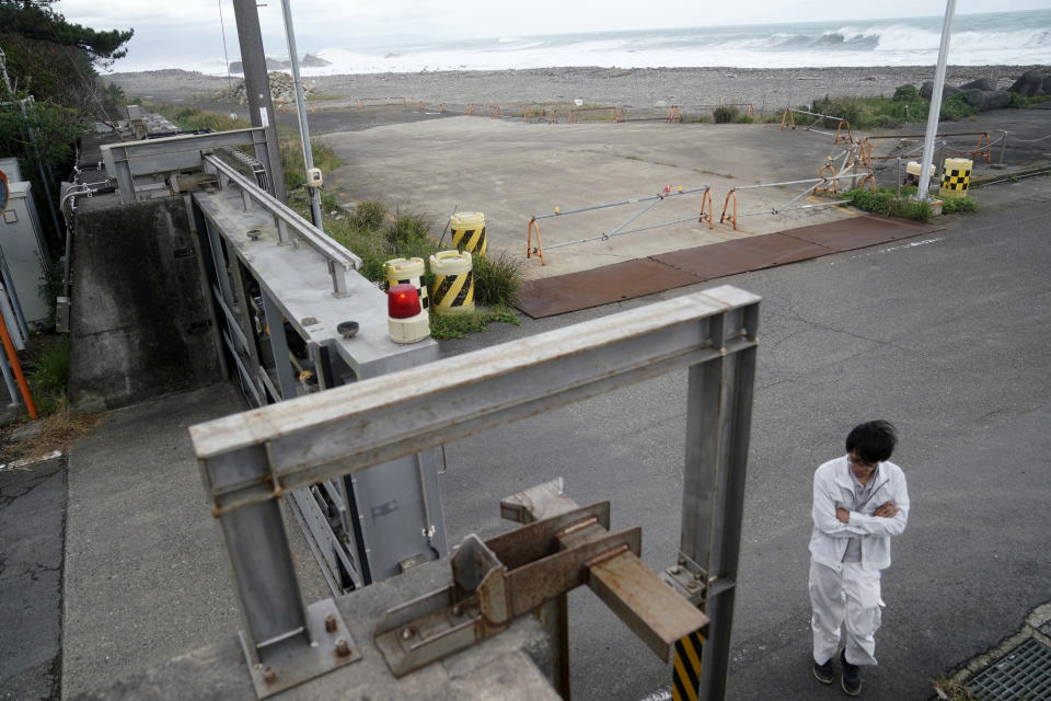 A Kiho town official prepares to close a door of a coastal levee as Typhoon Hagibis approaches at a port in town of Kiho, Mie prefecture, central Japan Friday, Oct. 11, 2019. A powerful typhoon is advancing toward the Tokyo area, where torrential rains are expected this weekend. (AP Photo/Toru Hanai)