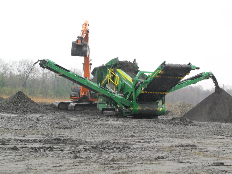 A machine sifts coal ash at the ash pond at Santee Cooper's Jefferies power generating station just outside Moncks Corner, S.C., on Feb. 26, 2014. The finer material in the pile at the right is trucked from the site and then used in the manufacture of concrete. Santee Cooper is South Carolina's state-owned electric and water utility. (AP Photo/Bruce Smith)