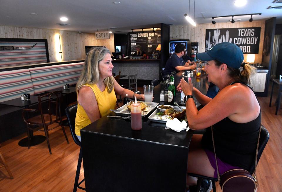 Friends Tammy Evans (left) and Kelly Arnold have lunch at Texas Cowboy BBQ Friday. The dining room was remodeled as part of the eatery's appearance on the Food Network show, Restaurant: Impossible.