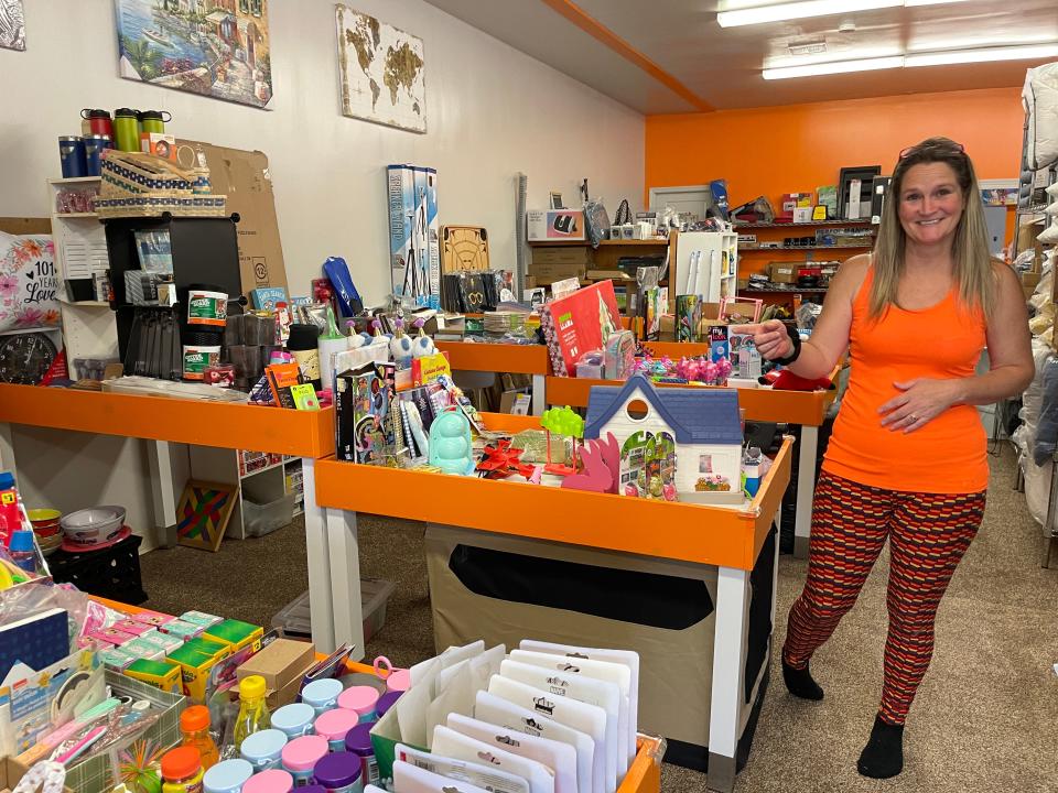 Melissa Walker-Schaefer shows some of the discounted merchandise at Dealz Dealz on Wednesday, Aug. 2, 2023.