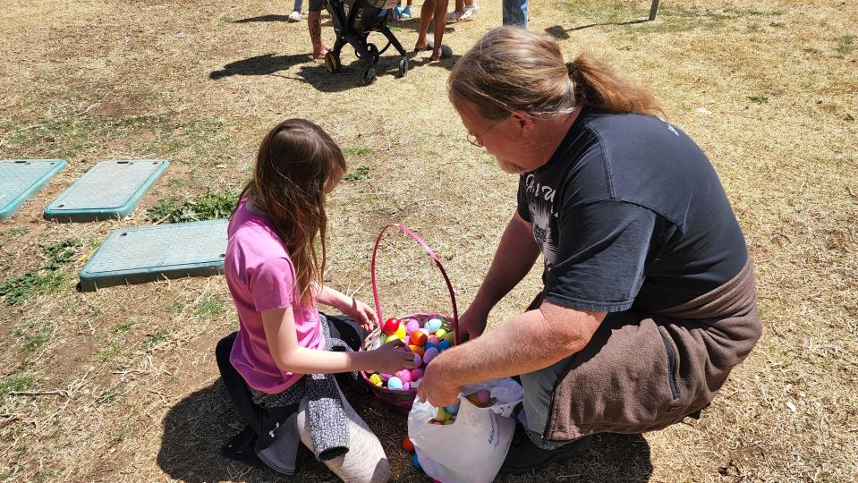 A father and daughter look over eggs collected at Bones Hooks Park during last year's "Christmas in April" at the Shi Lee's Easter Egg Hunt.