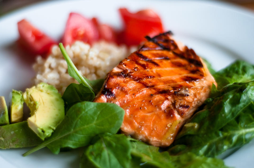 BBQ teriyaki salmon on spinach and arugula with brown rice, tomatoes and avocado