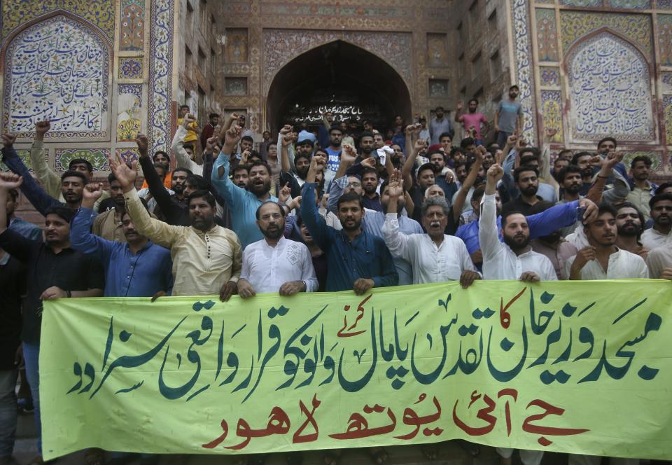 Supporters of the religious group Jamaat-e-Islami hold a banner reading "definitely punish those who violate the sanctity of Wazir Khan Mosque" at a demonstration outside the mosque, where actress Saba Qamar and singer Bilal Saeed shot a music video meant to depict a young bride’s joy, in Lahore, Pakistan, Sunday, Aug. 9, 2020. Social media trackers say a nationwide lockdown which lasted till early August, to curb the spread of the coronavirus sparked a 50% increase in internet use in this conservative Muslim nation of over 220 million people — along with an explosion of hate speech and incitement. (AP Photo/K.M. Chaudary)