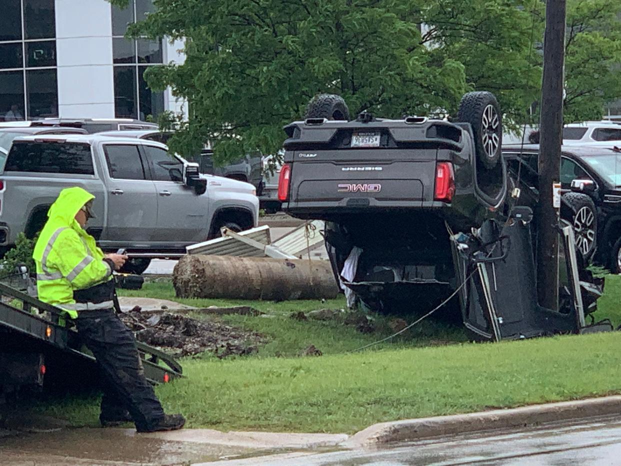A truck lies upended on a grassy area separating East Moreland Boulevard from two car dealerships west of Main Street early Tuesday afternoon. The truck struck a utility pole, which reportedly trapped the driver.