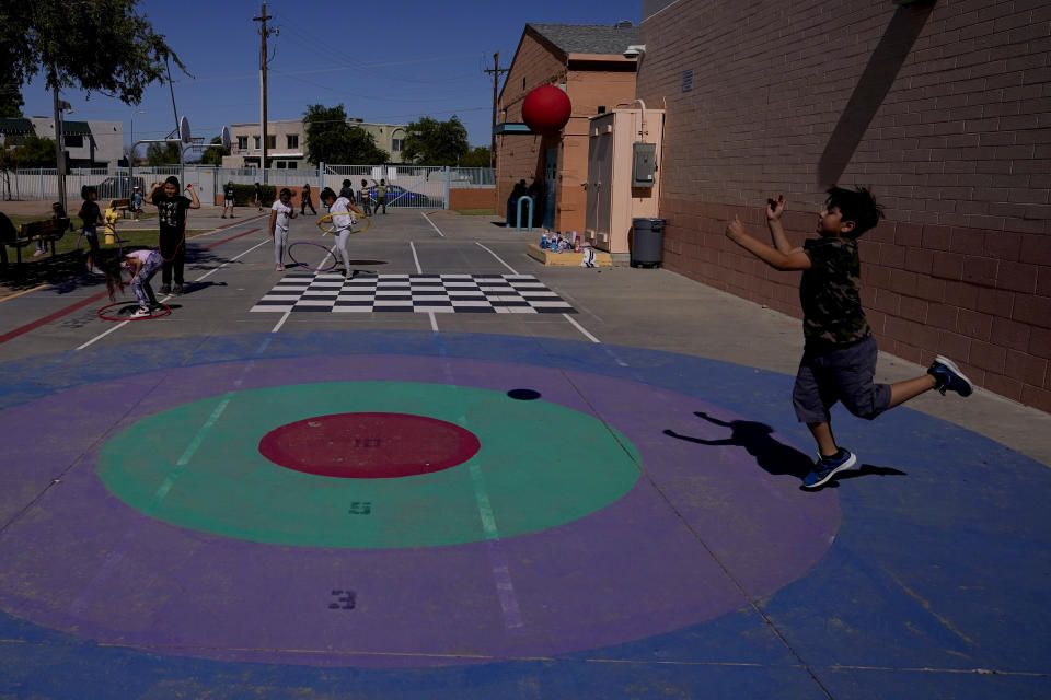 Whittier Elementary School students enjoy recess, Tuesday, Oct. 18, 2022 in Mesa, Ariz. Like many school districts across the country, Mesa has a teacher shortage due in part due to low morale and declining interest in the profession. Five years ago, Mesa allowed Whittier to participate in a program making it easier for the district to fill staffing gaps, grant educators greater agency over their work and make teaching a more attractive career. The model, known as team teaching, allows teachers to combine classes and grades rotating between big group instruction, one-on-one interventions, small study groups or whatever the team agrees is a priority each day. (AP Photo/Matt York)