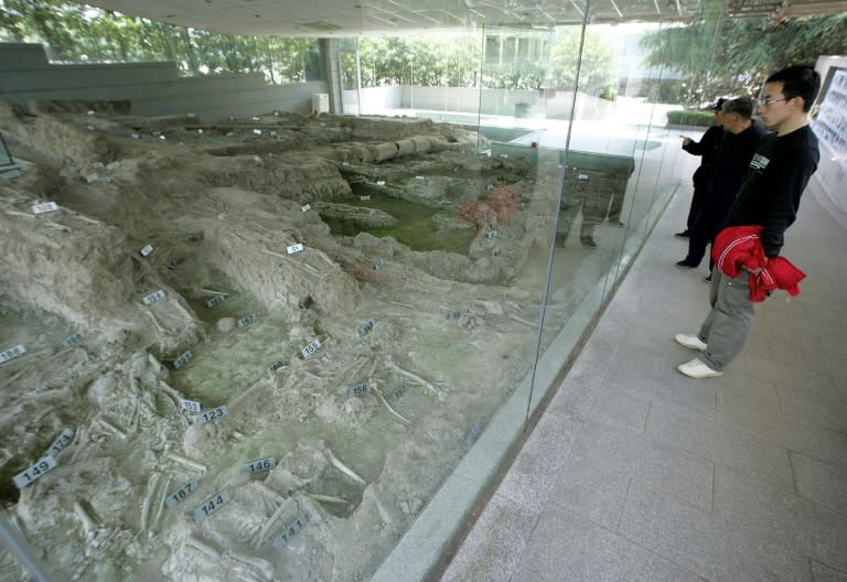 Chinese visitors view the remains of a mass grave at the Nanjing Massacre Memorial Hall