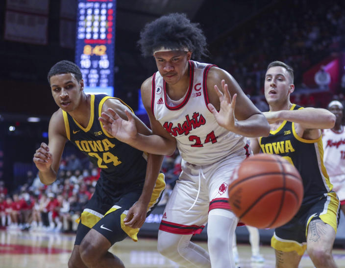 Iowa forward Kris Murray, left, and guard Connor McCaffery force Rutgers forward Ron Harper Jr. to lose the ball during the first half of an NCAA college basketball game Wednesday, Jan. 19, 2022, in Piscataway, N.J. (Andrew Mills/NJ Advance Media via AP)