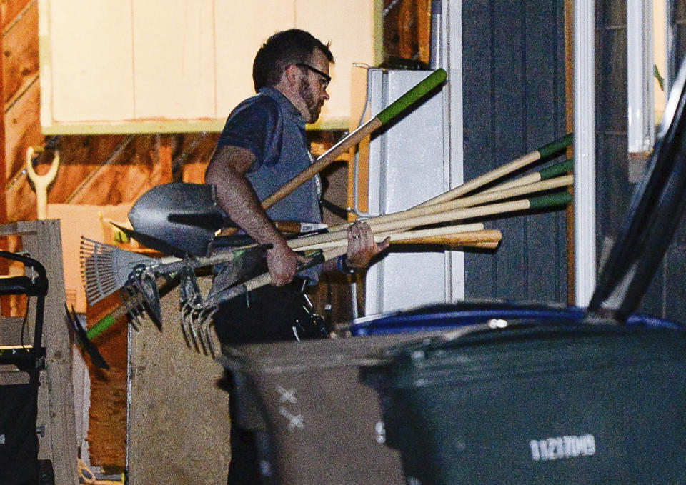 Police investigators carry in multiple rakes and shovels into the backyard of a home at 547 N. 1000 West in Salt Lake City as part of the disappearance of University of Utah student MacKenzie Lueck on Wednesday, June 26, 2019. Police said Thursday that the owner of a home they searched in connection with the disappearance is a "person of interest" and that they are trying to find a mattress that had been inside his home. (Francisco Kjolseth/The Salt Lake Tribune via AP)