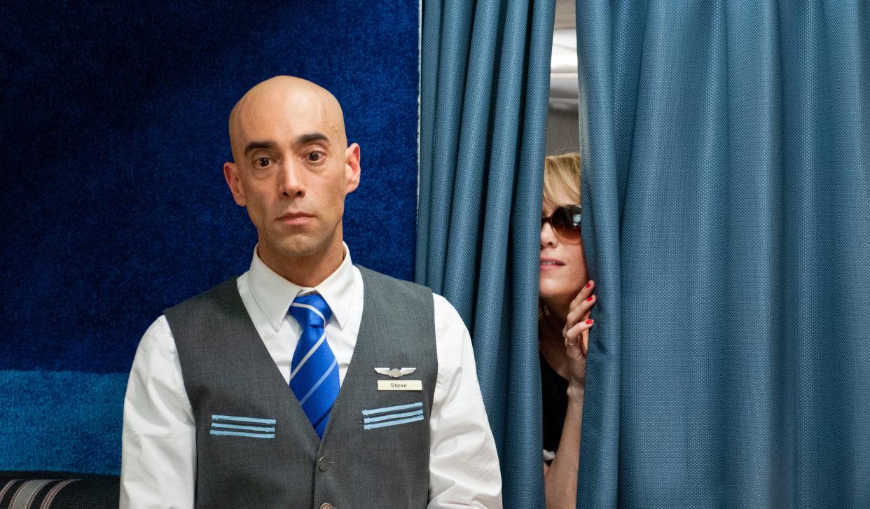 Steve (Mitch Silpa, left) struggles to keep Annie (Kristen Wiig) in line during an unruly trip to Vegas in "Bridesmaids."