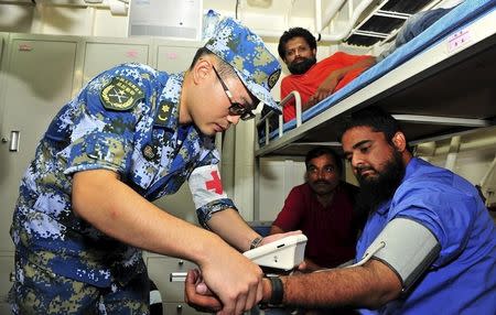 A Chinese solider of People's Liberation Army (PLA) checks the body condition of a non-Chinese citizen before an evacuation from Aden, April 2, 2015. REUTERS/Stringer