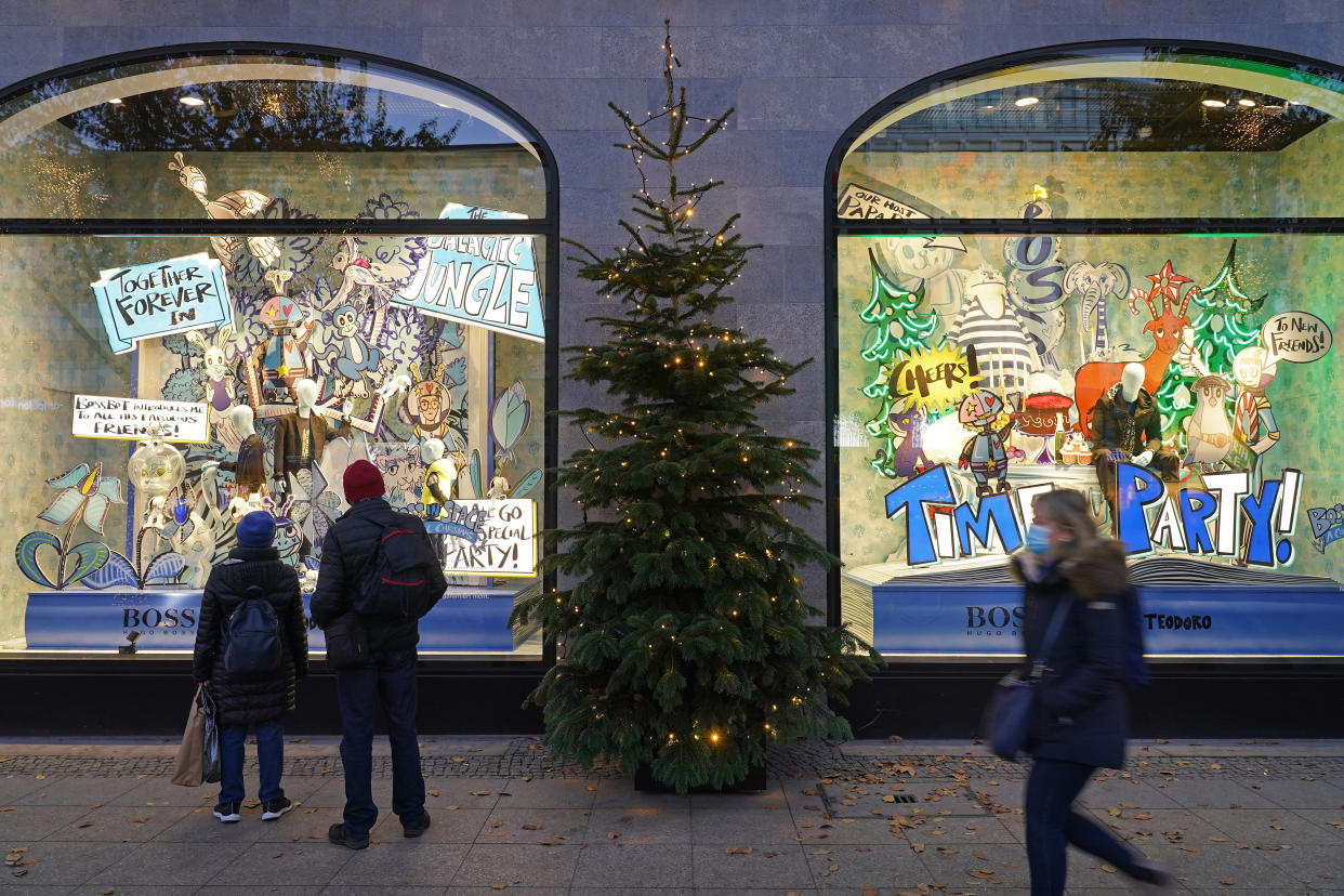 BERLIN, GERMANY - NOVEMBER 23: People wearing protective face masks walk past Christmas display windows of KaDeWe department store during the second wave of the coronavirus pandemic on November 23, 2020 in Berlin, Germany. The Christmas season is beginning muted in Berlin, with traditional Christmas markets that would normally open today all cancelled. Germany is in the midst of November semi-lockdown measures that political leaders will likely be extended until December 20 as authorities continue to struggle to bring down coronavirus infection rates.  (Photo by Sean Gallup/Getty Images)