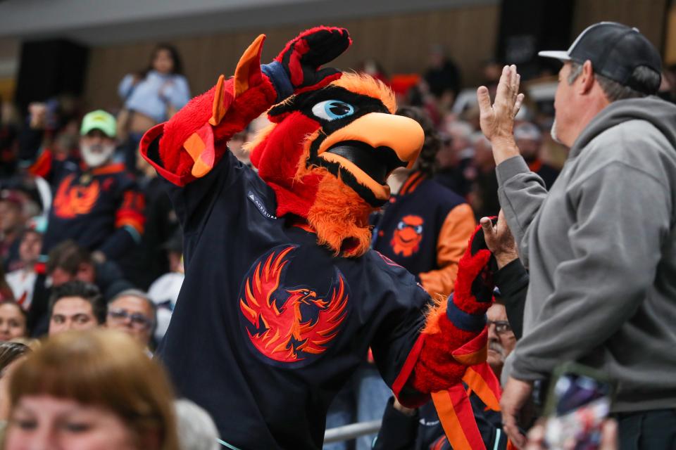 Fuego high fives a fan during the first period of the game between the Firebirds and Reign at Acrisure Arena in Palm Desert, Calif., on Wed., April 10, 2024.