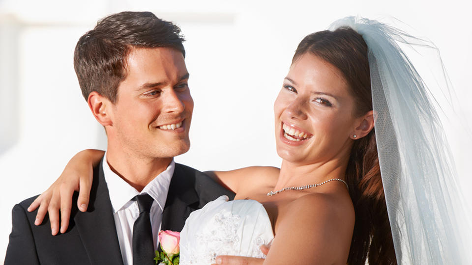 Smiling couple on wedding day resemble bride and groom turning profit off wedding guests at cash bar