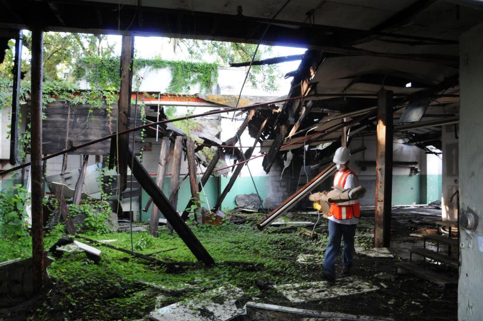 In this 2010 photo, Travis Higgs carries materials out of a commercial building on Swan Street in the area now known as Jacksonville's Railyard District before commencing the building's demolition for a Jacksonville Journey project.