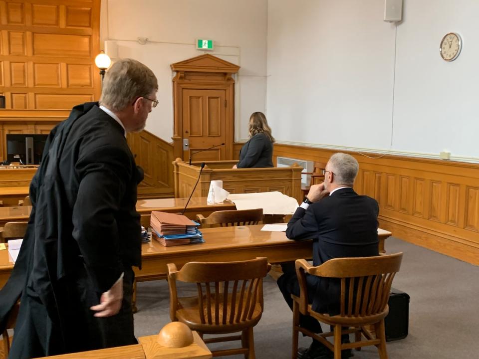 Royal Newfoundland Constabulary officer Nicole Percey stands in the witness box during a break in proceedings Monday. Regular, who is accused of sexual violence, is seated facing her. 