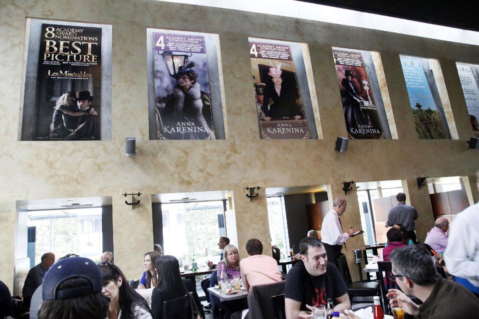 This Thursday, Feb. 21, 2013 photo shows people having lunch beneath Oscar posters at Kate Mantilini restaurant in Beverly Hills, Calif. The 85th Academy Awards are held on Sunday, Feb. 24, 2013, in Los Angeles. (AP Photo/Nick Ut)