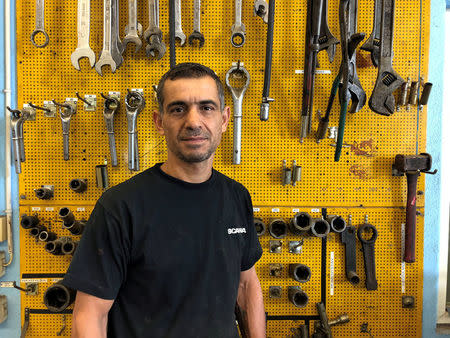 Muhsen Mousa, a 42-year-old Syrian refugee, who is employed as a mechanic at Scania's Swedish retail business poses at the companyÕs workshop on the outskirts of Stockholm, Sweden July 6, 2018. Picture taken July 6, 2018. REUTERS/Esha Vaish