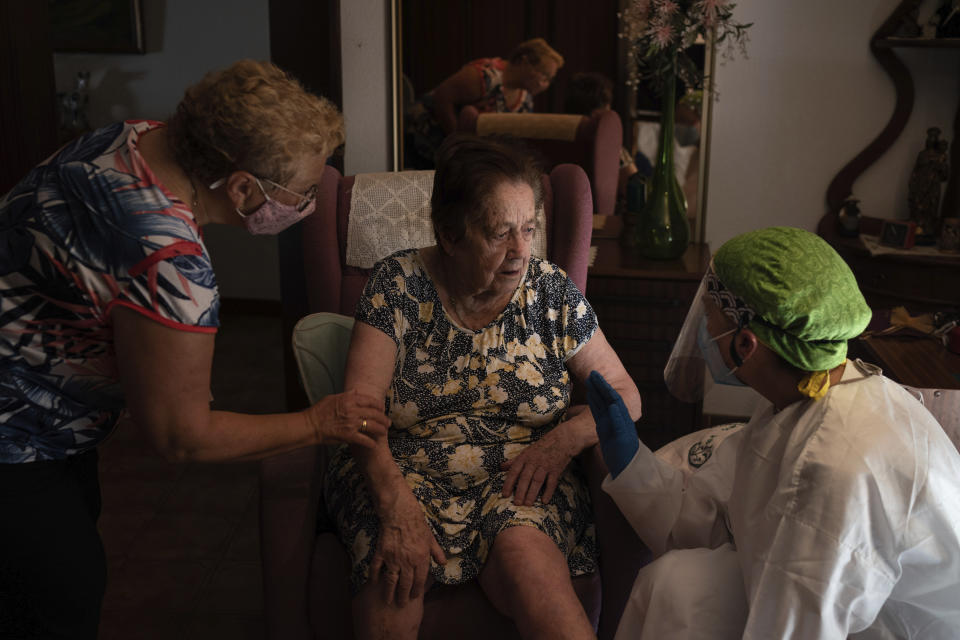 In this Friday, July 31, 2020 file photo, Dr. Marta Ruberte, right, talks to 94-year-old Maria Lluisa Olivella during a home visit in Sant Sadurní d'Anoia, Catalonia region, Spain. Olivella was feeling tired but according to the Doctor is not suspected of having coronavirus. In contrast to the darkest weeks of March and April, when the virus ripped through Spain's elderly in nursing homes and pushed the country's hospitals to the breaking point, the pressure is now on Spain's neighborhood health clinics. (AP Photo/Felipe Dana)