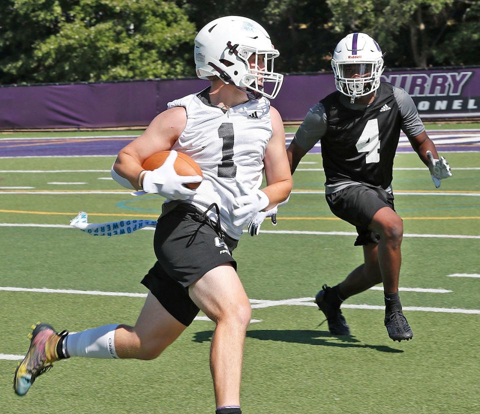 Running back Max Bell carries the ball during a Curry College football practice on Friday, Aug. 12, 2022.