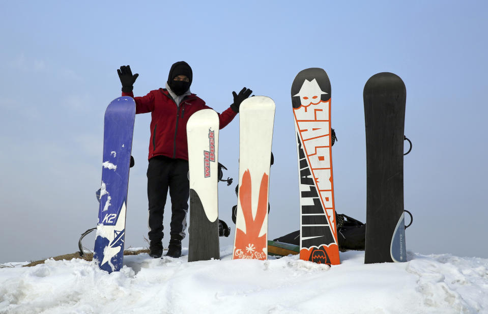 In this Friday, Jan. 24, 2020 photo, Ahmad Romal Hayat, 22, who founded the Afghanistan Snowboarding Federation, adjust snowboards during a practice session on the outskirts of Kabul, Afghanistan. As a teenager, Hayat started out on a skateboard. Later, he bought a snowboard in neighboring Iran and said he’s the first person to bring a snowboard into Afghanistan. He and handful of federation members are looking to put the city on the winter sports map and change perceptions about their war-weary nation. (AP Photo/Rahmat Gul)