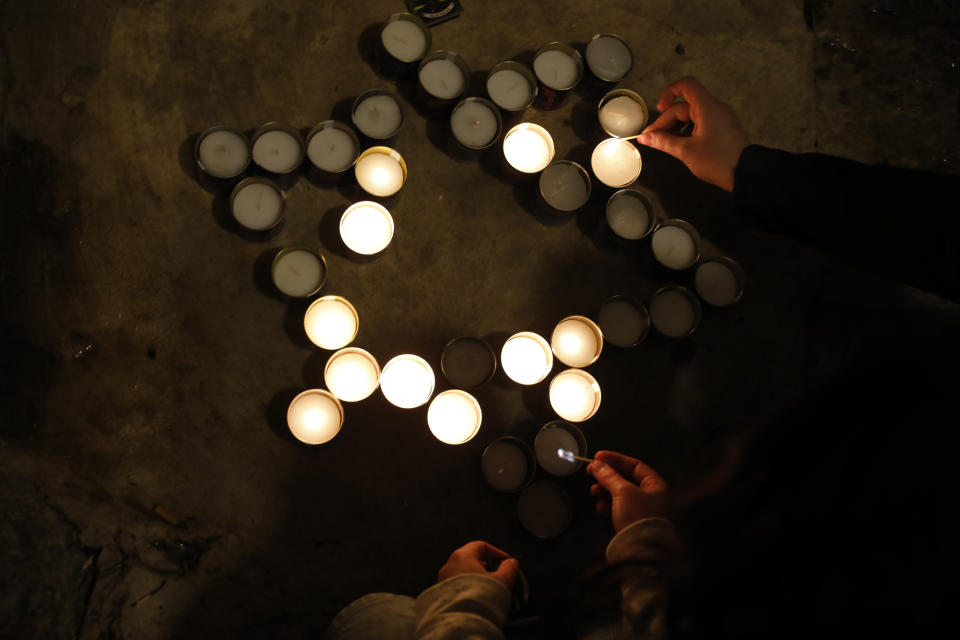 Israeli youth light candles in the shape of the Star of David at the site of a shooting attack that killed an Israeli man in Jerusalem's Old City, Sunday, Nov. 21, 2021. A Hamas militant opened fire in Jerusalem's Old City, killing the 26-year-old Israeli and wounding four other people before he was fatally shot by Israeli police. (AP Photo/Ariel Schalit)
