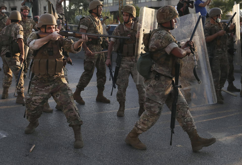 A Lebanese army soldier fires rubber bullets against the anti-government protesters, during a protest against the Lebanese President Michel Aoun near the presidential palace, in Baabda east of Beirut, Lebanon, Saturday, Sept. 12, 2020. Soldiers fired rubber bullets and live rounds in the air to disperse hundreds of protesters trying to march to the presidential palace during an anti-government demonstration. (AP Photo/Bilal Hussein)