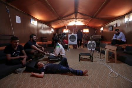 A displaced Syrian refugee attends a session at a physiotherapy clinic inside a large tent near Azaz