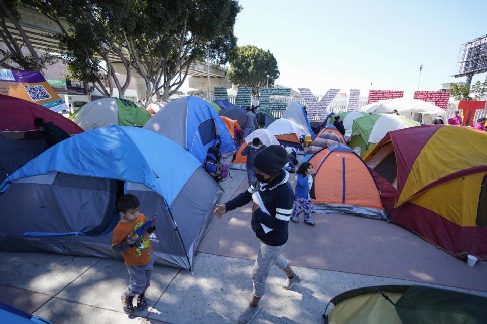 People walk among tents crowded next to large letters reading "Mexico" in green, white and red.