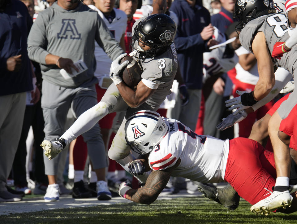 Colorado running back Dylan Edwards (3) is pushed out of play by Arizona linebacker Jacob Manu, bottom, in the second half of an NCAA college football game on Saturday, Nov. 11, 2023, in Boulder, Colo. (AP Photo/David Zalubowski)