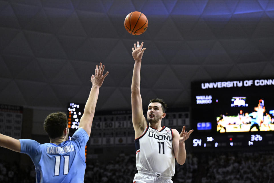 UConn forward Alex Karaban (11) shoots over Creighton center Ryan Kalkbrenner (11) in the second half of an NCAA college basketball game, Wednesday, Jan. 17, 2024, in Stores, Conn. (AP Photo/Jessica Hill)