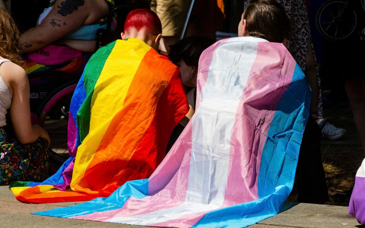 Protesters draped in Rainbow Pride and Transgender flags in London