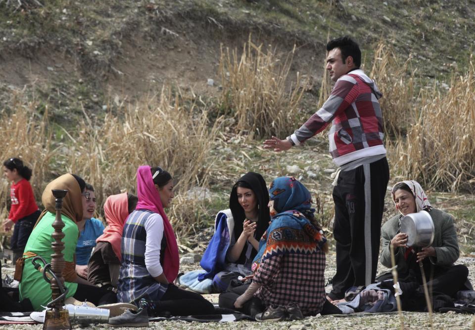 An Iranian man dances among his family members while spending time outdoors observing the ancient festival of Sizdeh Bedar, an annual public picnic day on the 13th day of the Iranian new year, in Tehran, Iran, Wednesday, April 2, 2014. Sizdeh Bedar, which comes from the Farsi words for “thirteen” and “day out,” is a legacy from Iran’s pre-Islamic past that hard-liners in the Islamic Republic never managed to erase from calendars. Many say it’s bad luck to stay indoors for the holiday. (AP Photo/Vahid Salemi)