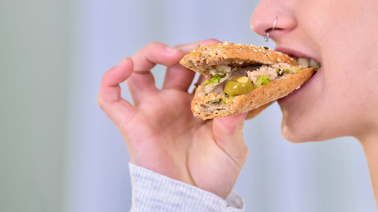 woman eating a tuna sandwich