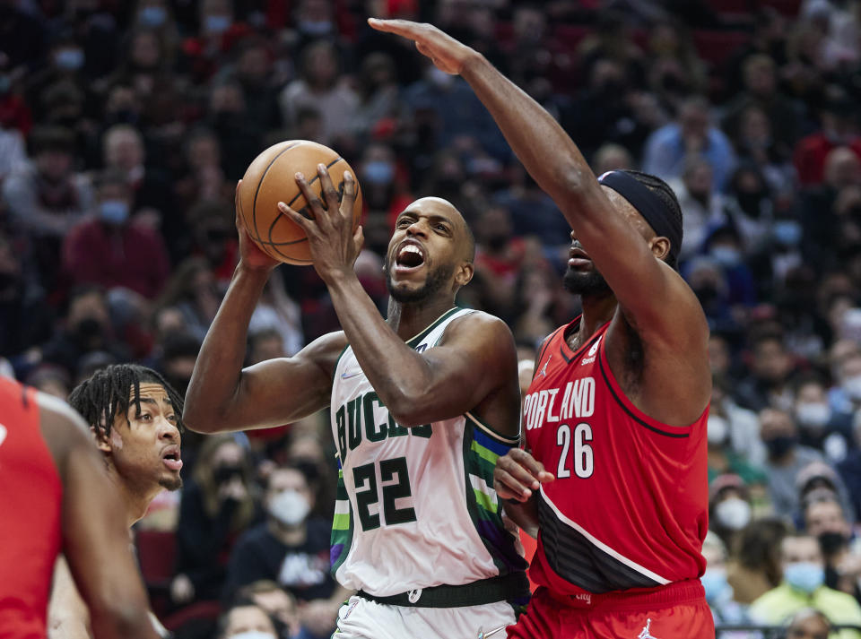 Milwaukee Bucks forward Khris Middleton, center, drives to the basket between Portland Trail Blazers forwards Justise Winslow, right, and Trendon Watford during the first half of an NBA basketball game in Portland, Ore., Saturday, Feb. 5, 2022. (AP Photo/Craig Mitchelldyer)