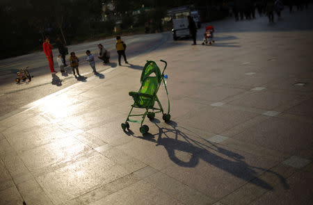 FILE PHOTO: A baby stroller is seen as mothers play with their children at a public area in downtown Shanghai November 19, 2013. REUTERS/Carlos Barria