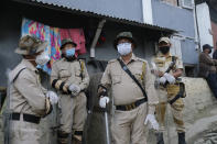 Security officers wearing face masks as a preventive measure against the coronavirus keep guard outside a polling booth during by-elections in Kohima, capital of the northeastern Indian state of Nagaland, Tuesday, Nov. 3, 2020. Elections are being held in two constituencies in the state after the seats fell vacant following the demise of their respective lawmakers. (AP Photo/Yirmiyan Arthur)