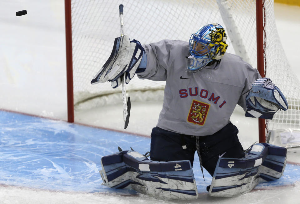 Goalkeeper of Finland's women's ice hockey team Raty Noora eyes a puck during a practice session ahead of the 2014 Winter Olympics, Thursday, Feb. 6, 2014, in Sochi, Russia. (AP Photo/Julio Cortez)